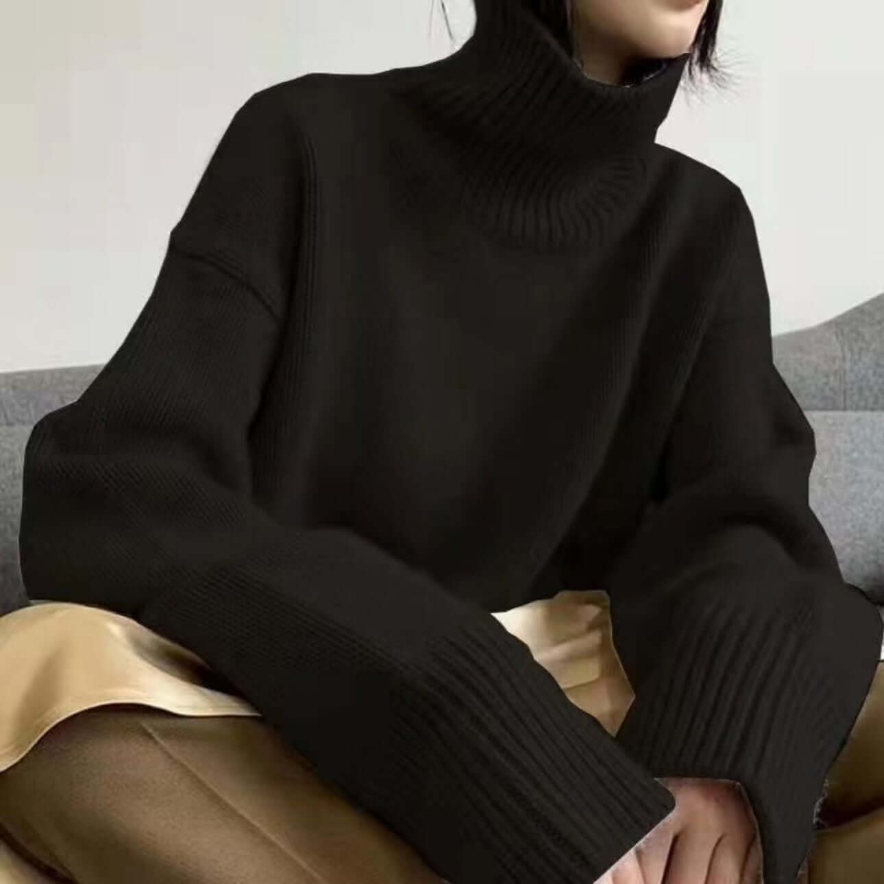 Front view of black high neck sweater on female model