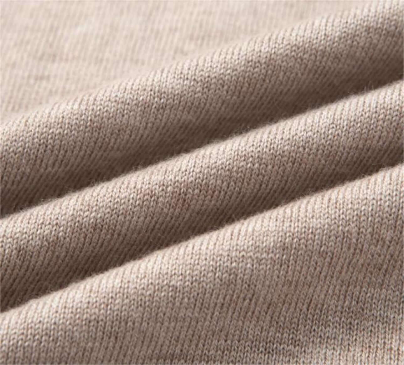 Close-up of the soft texture of a polo wool sweater fabric in beige color.