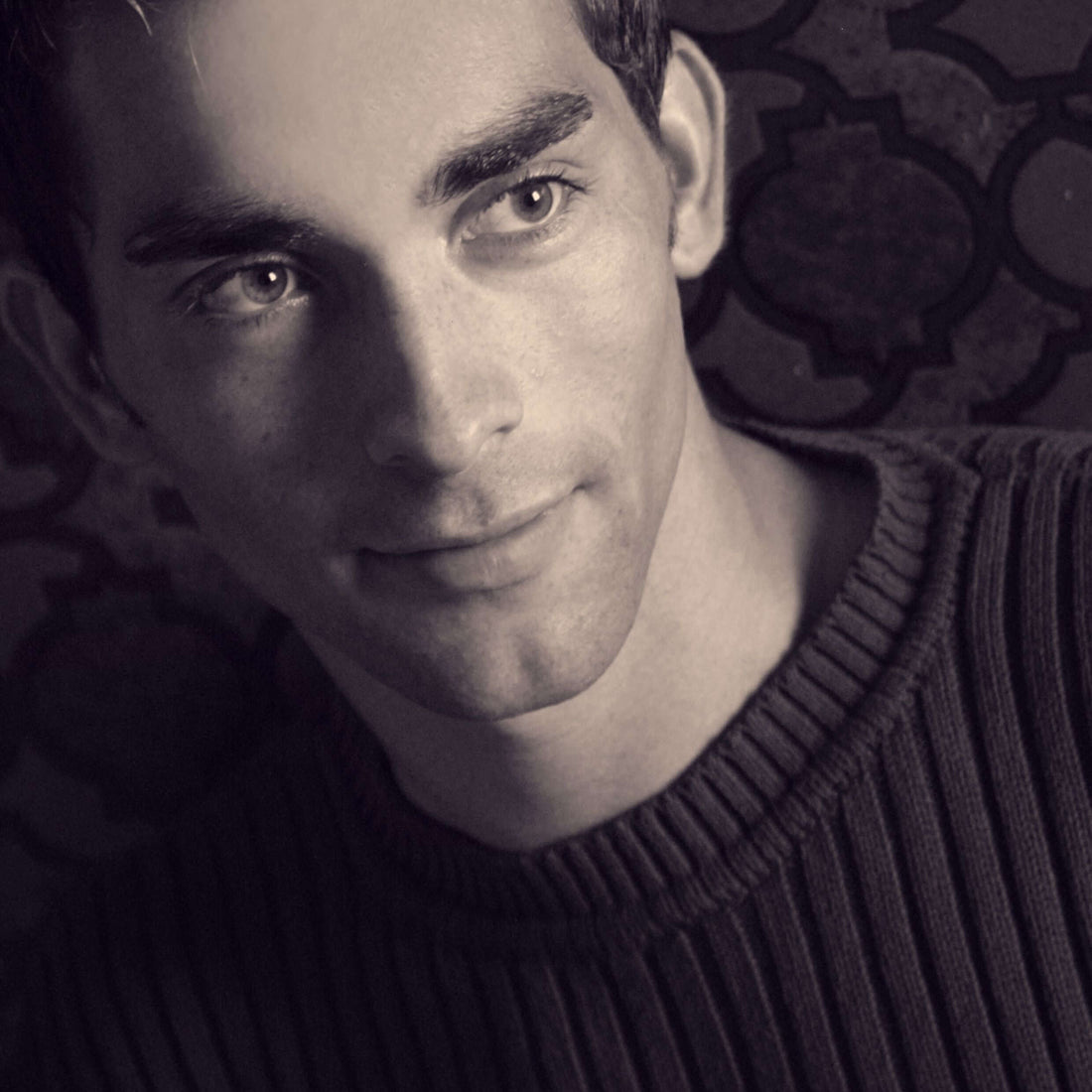 Close-up of a young man wearing a round-neck sweater, showcasing a timeless fashion staple.