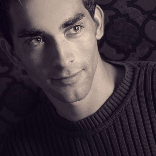 Close-up of a young man wearing a round-neck sweater, showcasing a timeless fashion staple.