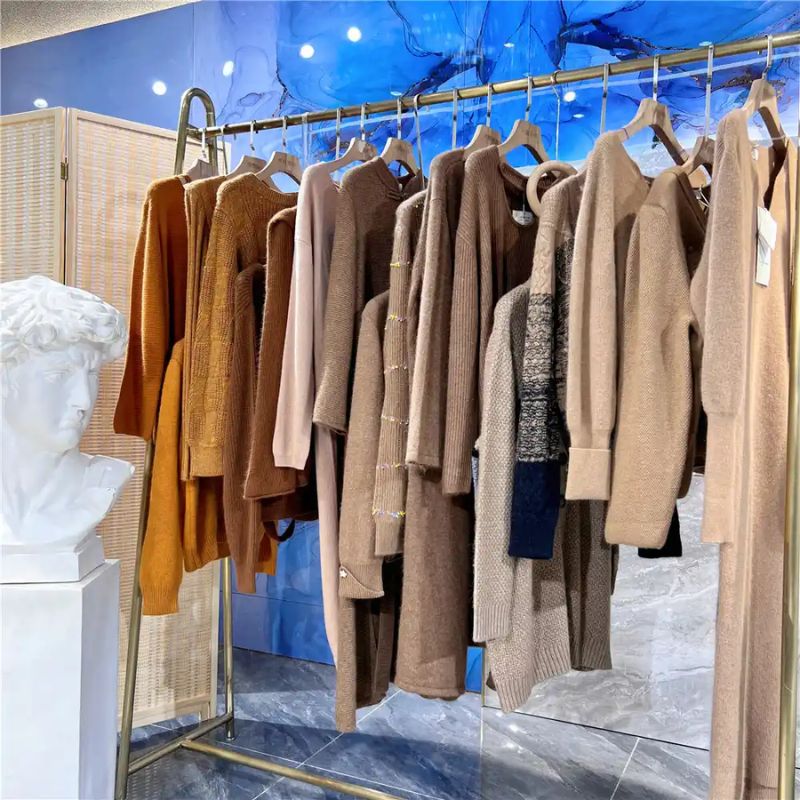 Knitwear Supplier Australia vs EU: Display of various knitwear styles on hangers in a boutique setting.