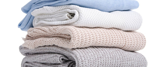 Stack of cozy fabrics including turtleneck sweater materials in various colors.
