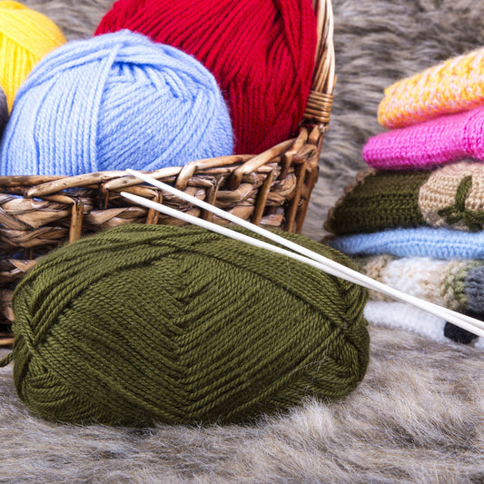 Warm Wool Sweater supplies with colorful yarn and knitting needles in a cozy setting.