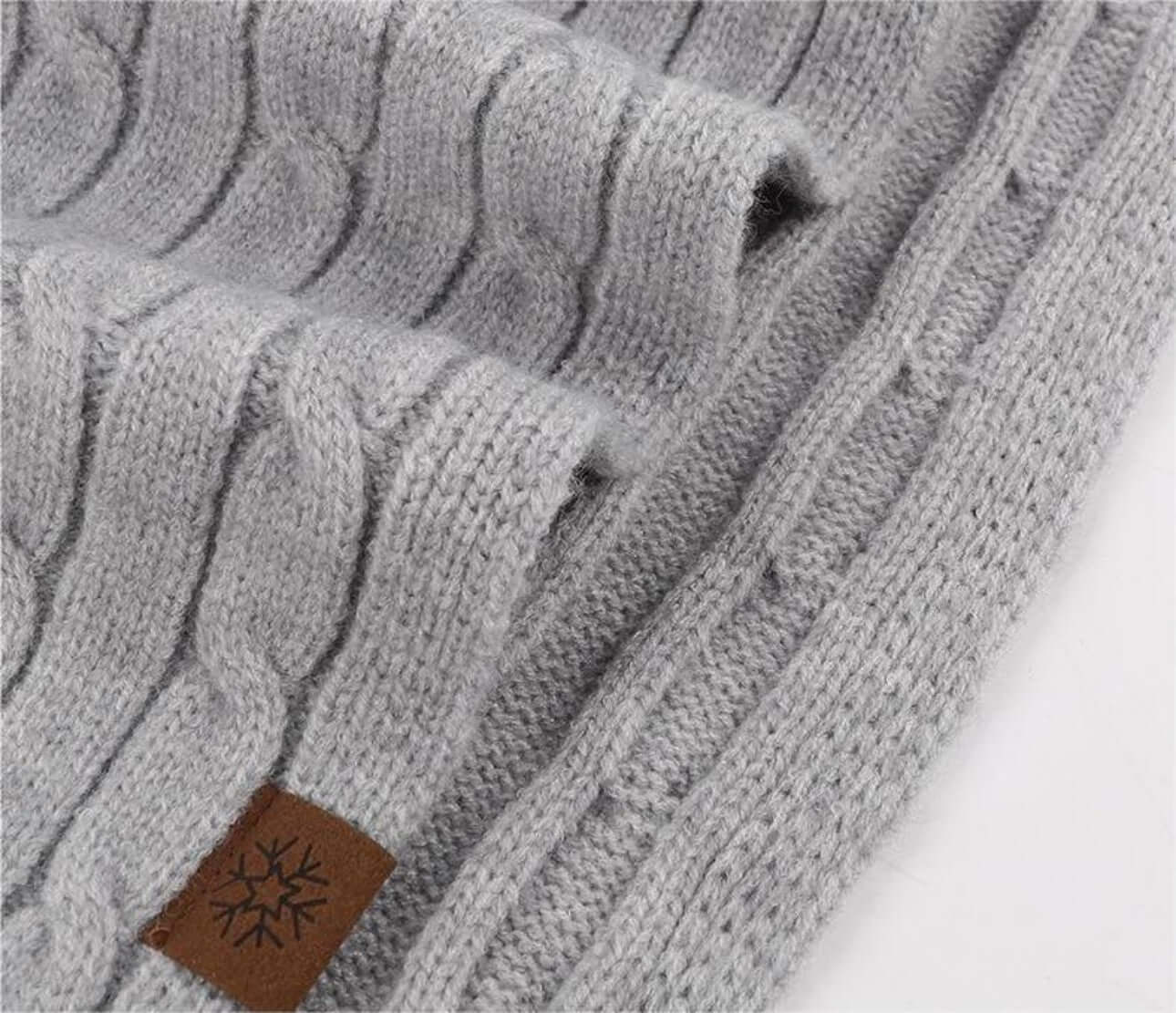 Thick Cable-Knit Scarf OEM in light gray color with textured design and leather tag for winter fashion.