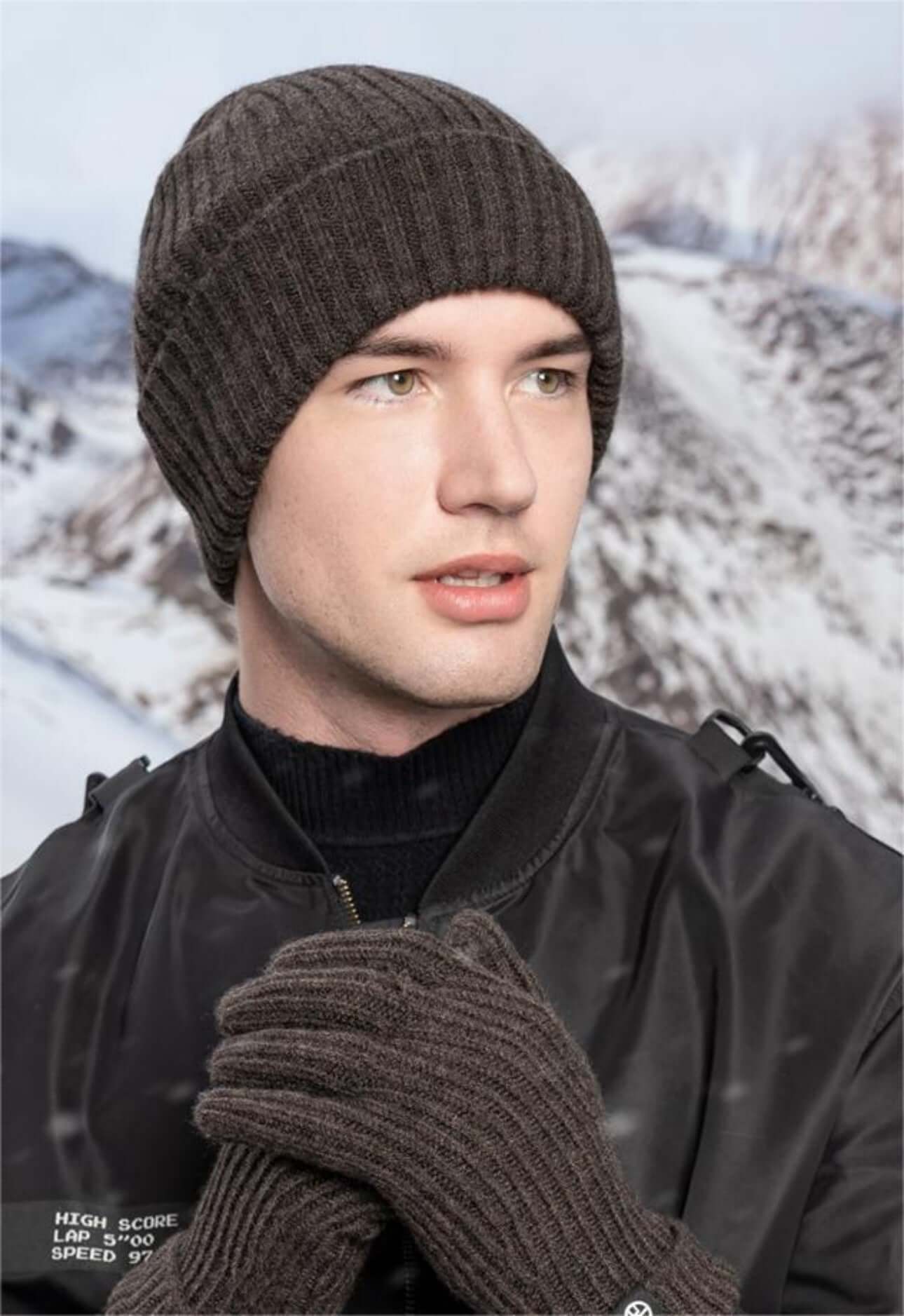 Men wearing cold proof hat and gloves set against a snowy background, showcasing winter knitwear style.