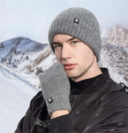 Cold proof hat and gloves set worn by a man against a snowy mountain backdrop.