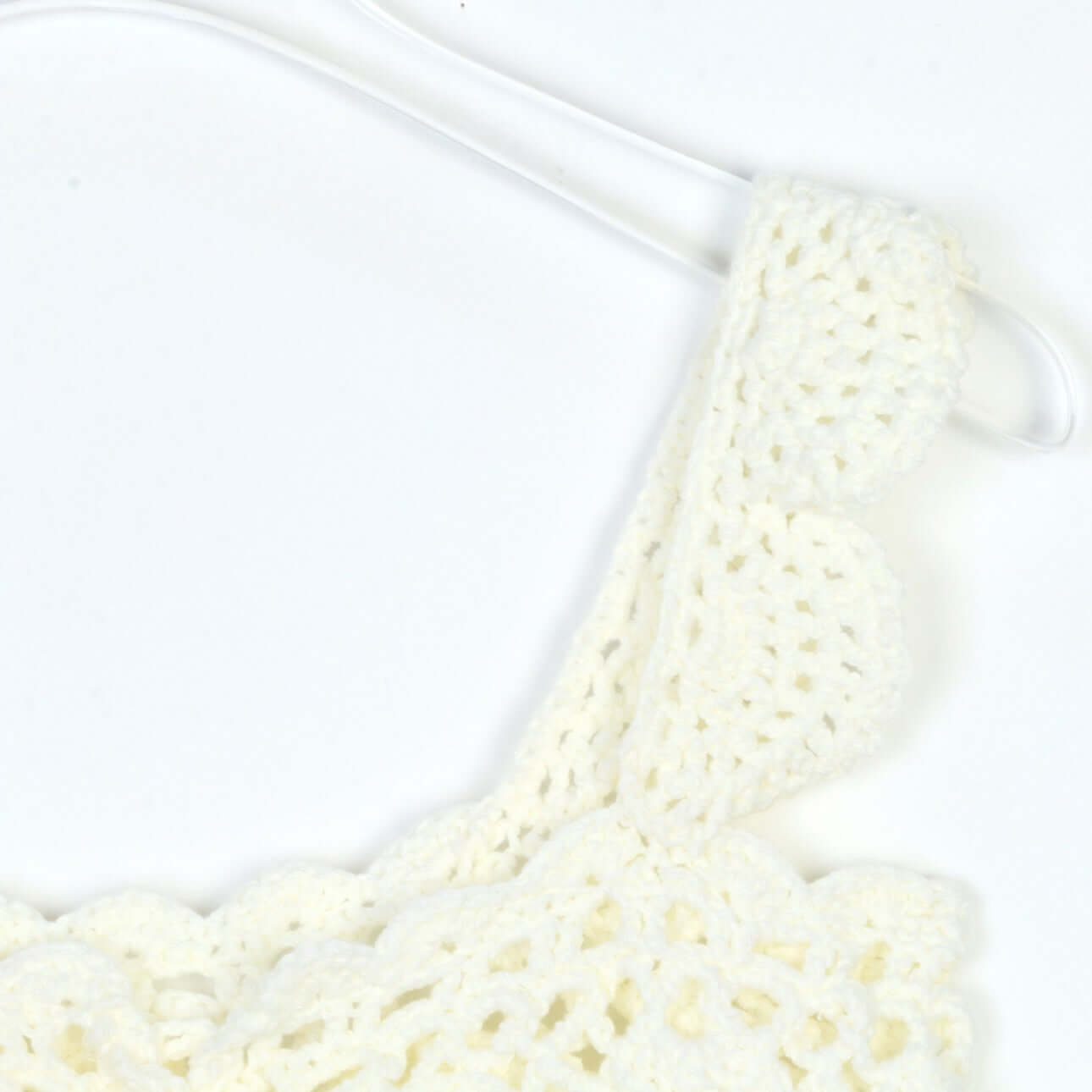 Hand Crochet Sleeveless Top Manufacturer | Detailed view of the crochet pattern and adjustable strap on a white top.
