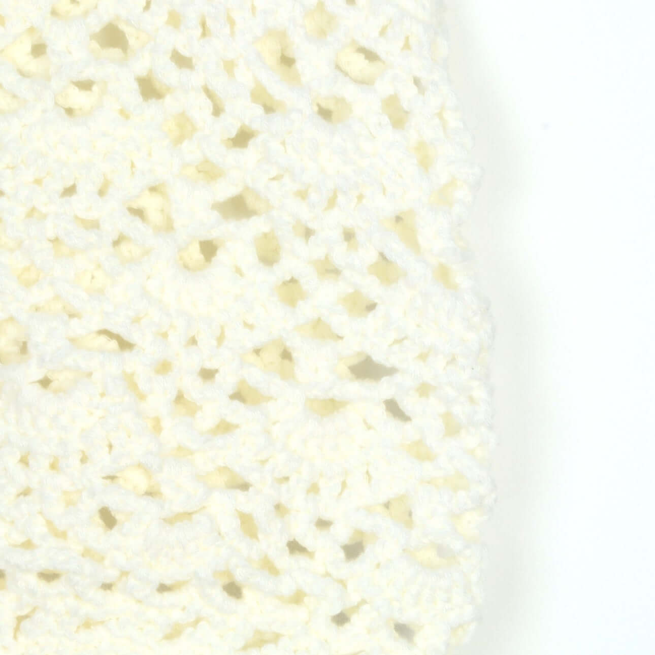 Close-up of a hand-crocheted sleeveless top by Hand Crochet Sleeveless Top Manufacturer in a cream color.