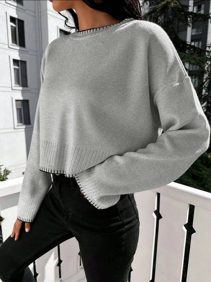 Cropped Loose Sweater OEM in gray worn with black jeans outdoors, showcasing stylish casual wear.