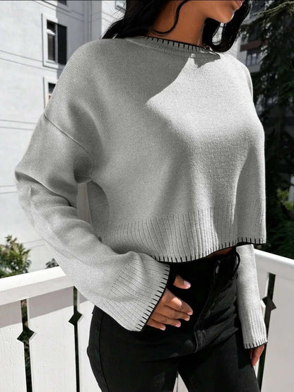 Cropped Loose Sweater OEM in light gray worn with black pants, featuring a loose fit and ribbed detail.