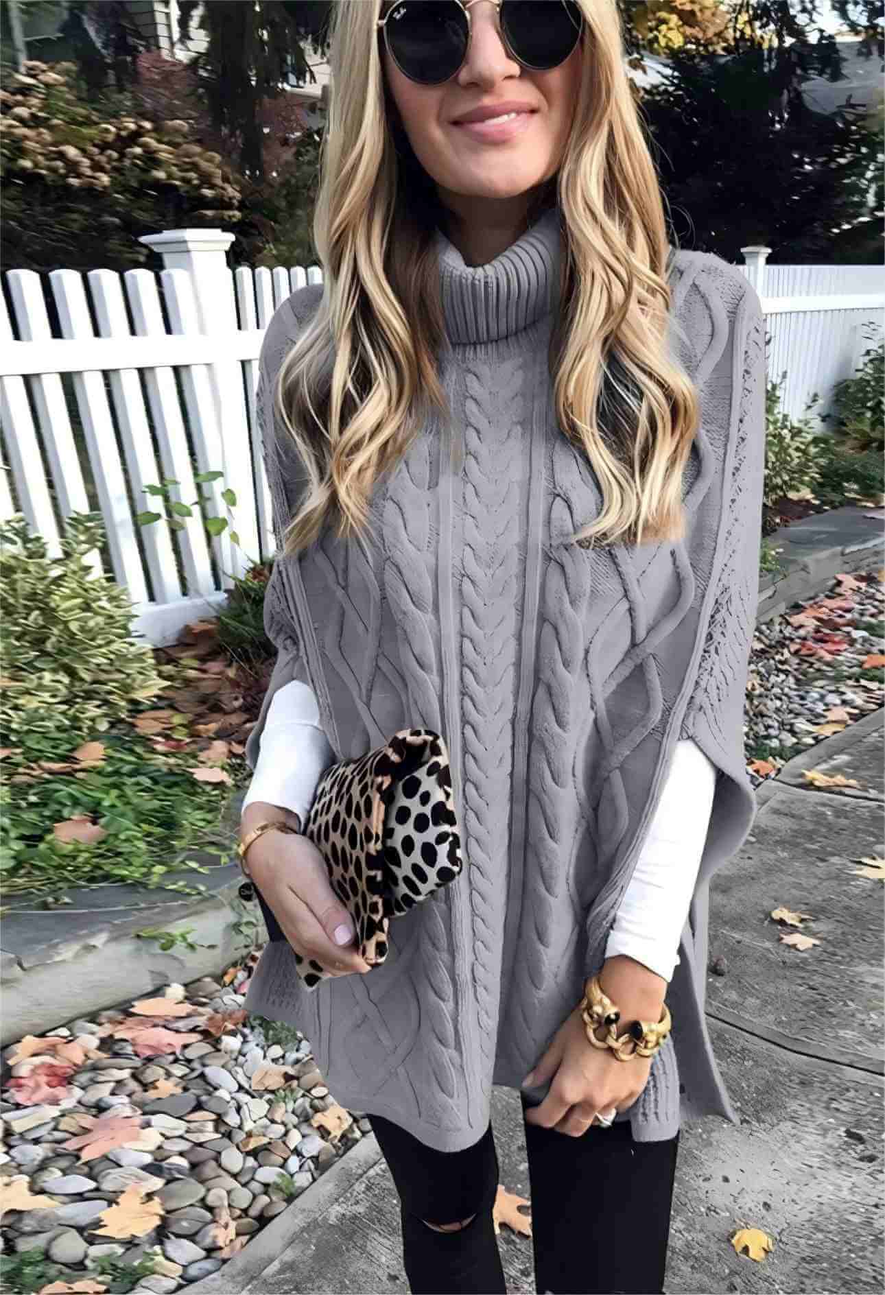 Front view of light gray high neck cape sweater on model.