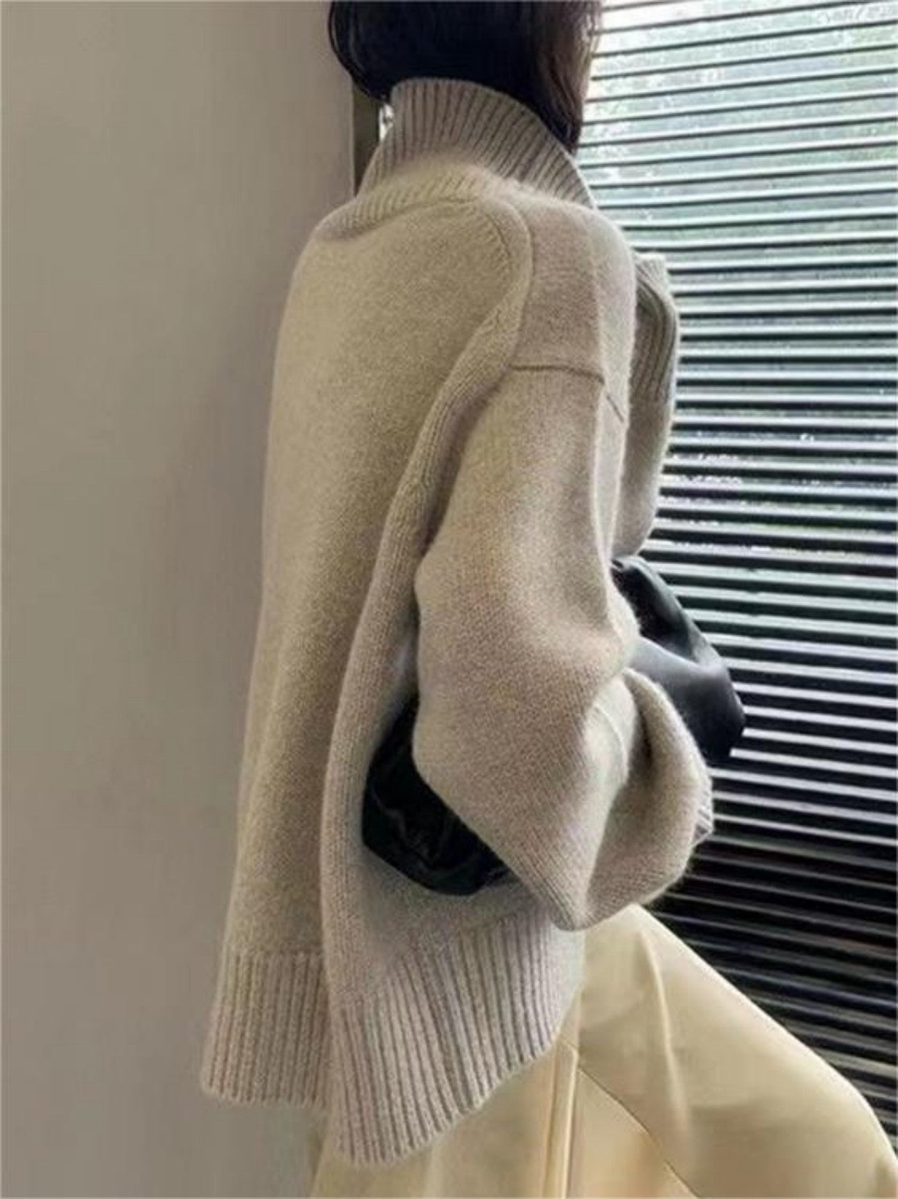 Side view of model in apricot high neck sweater