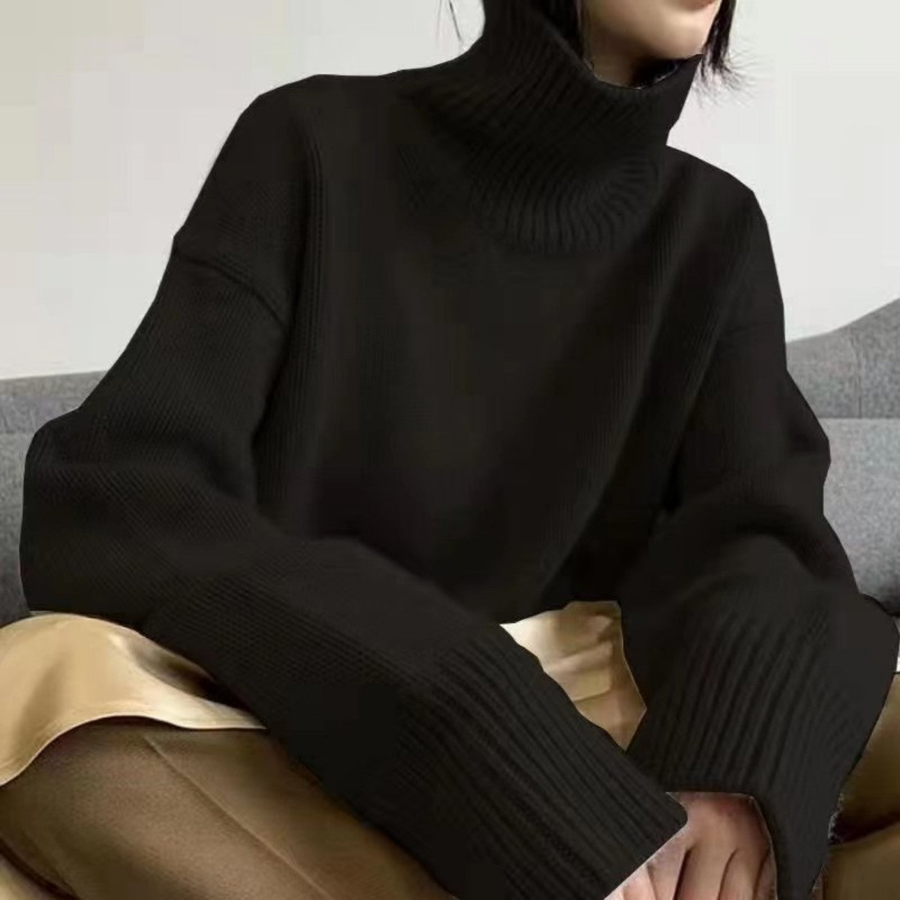 Front view of black high neck sweater on female model