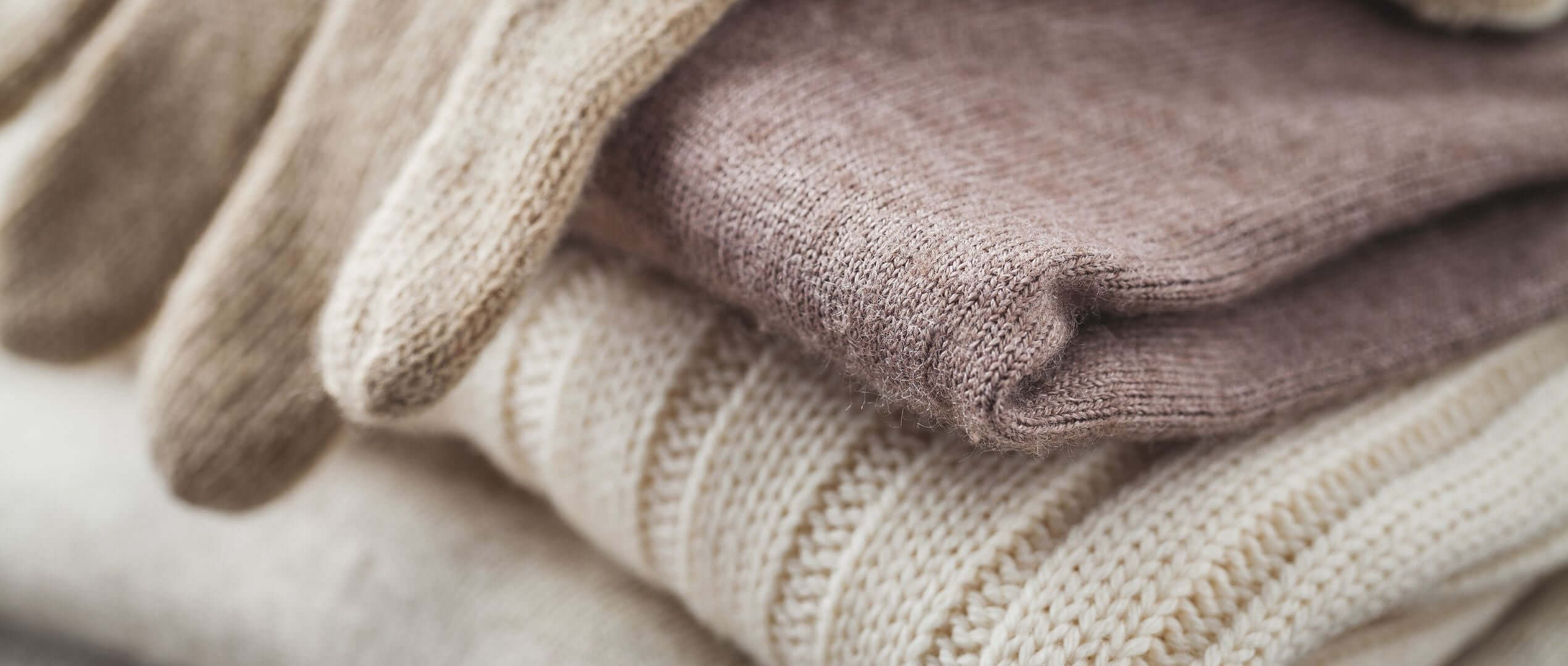 Coordinated knit sweater and gloves set in a flatlay display, offering retailers a complete seasonal product solution for their inventory.