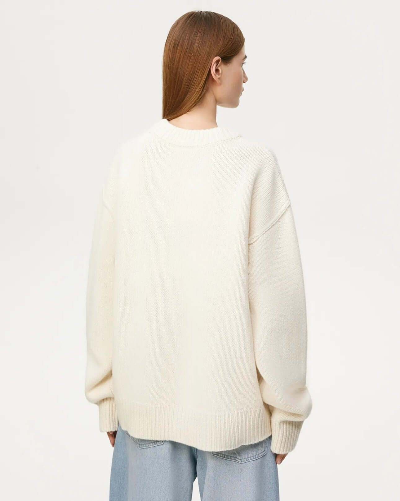 Back view of beige long sleeve round neck sweater.