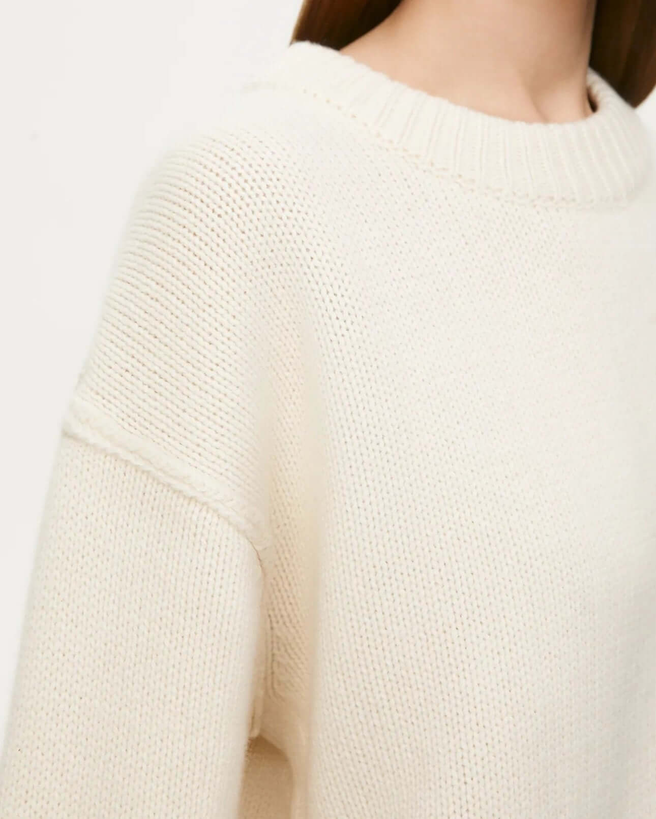 Neckline detail of beige long sleeve round neck sweater.