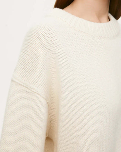 Neckline detail of beige long sleeve round neck sweater.