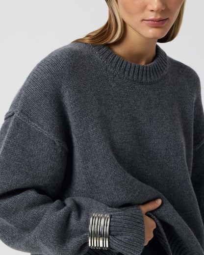 Women's Long Sleeve Round Neck Sweater in dark gray with drop shoulder design and stylish silver bangles.
