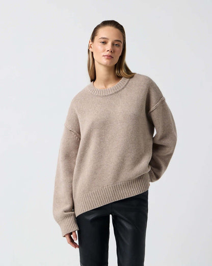 Woman modeling wheat colored long sleeve round neck sweater with drop shoulder, front view.