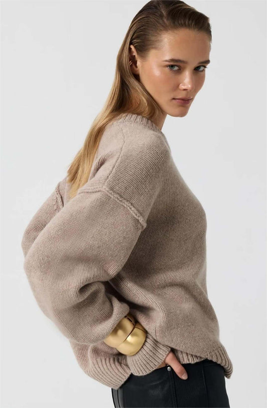 Side profile view of model in wheat long sleeve round neck sweater.