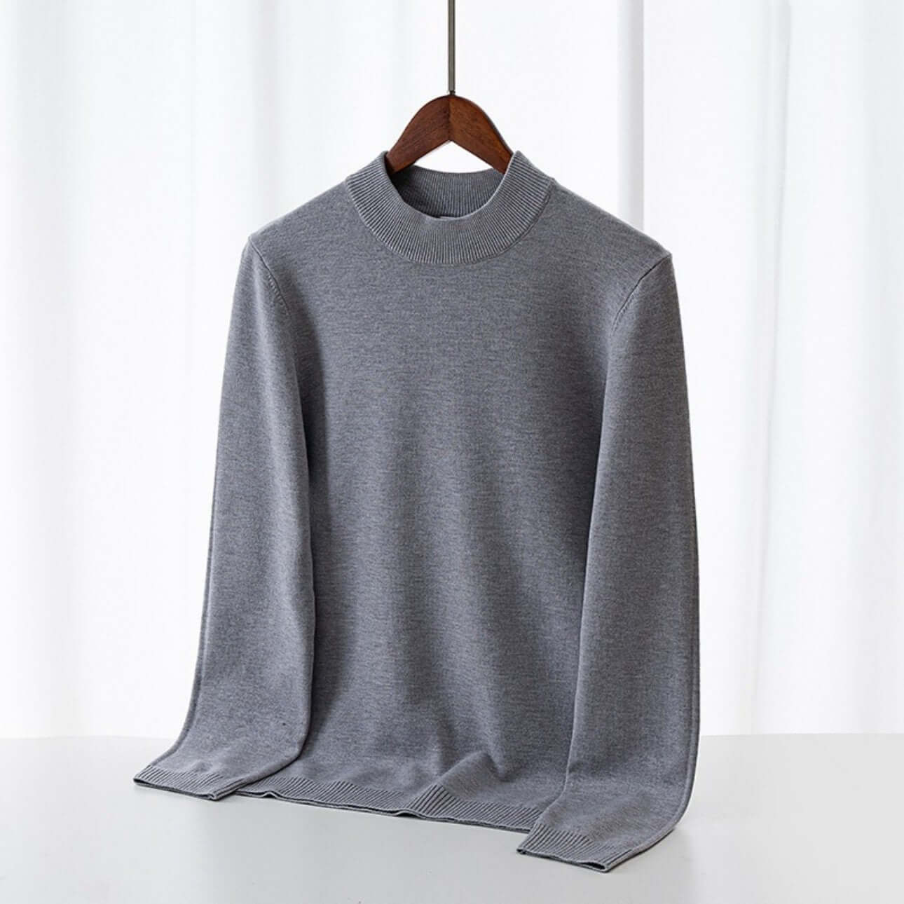 Men's Wool Sweater OEM - Thick round-neck grey wool sweater displayed on a hanger against a light background.