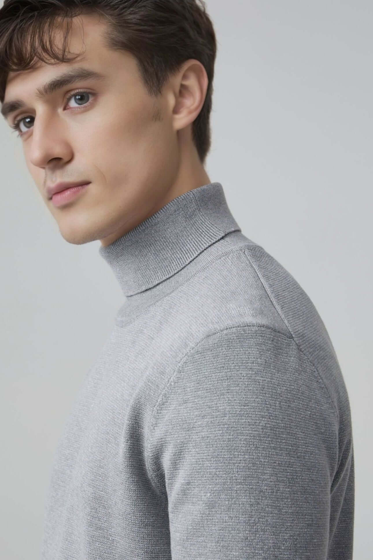 Men's Wool Turtleneck OEM - Model wearing a stylish thick high neck grey sweater, showcasing versatile knitwear fashion.