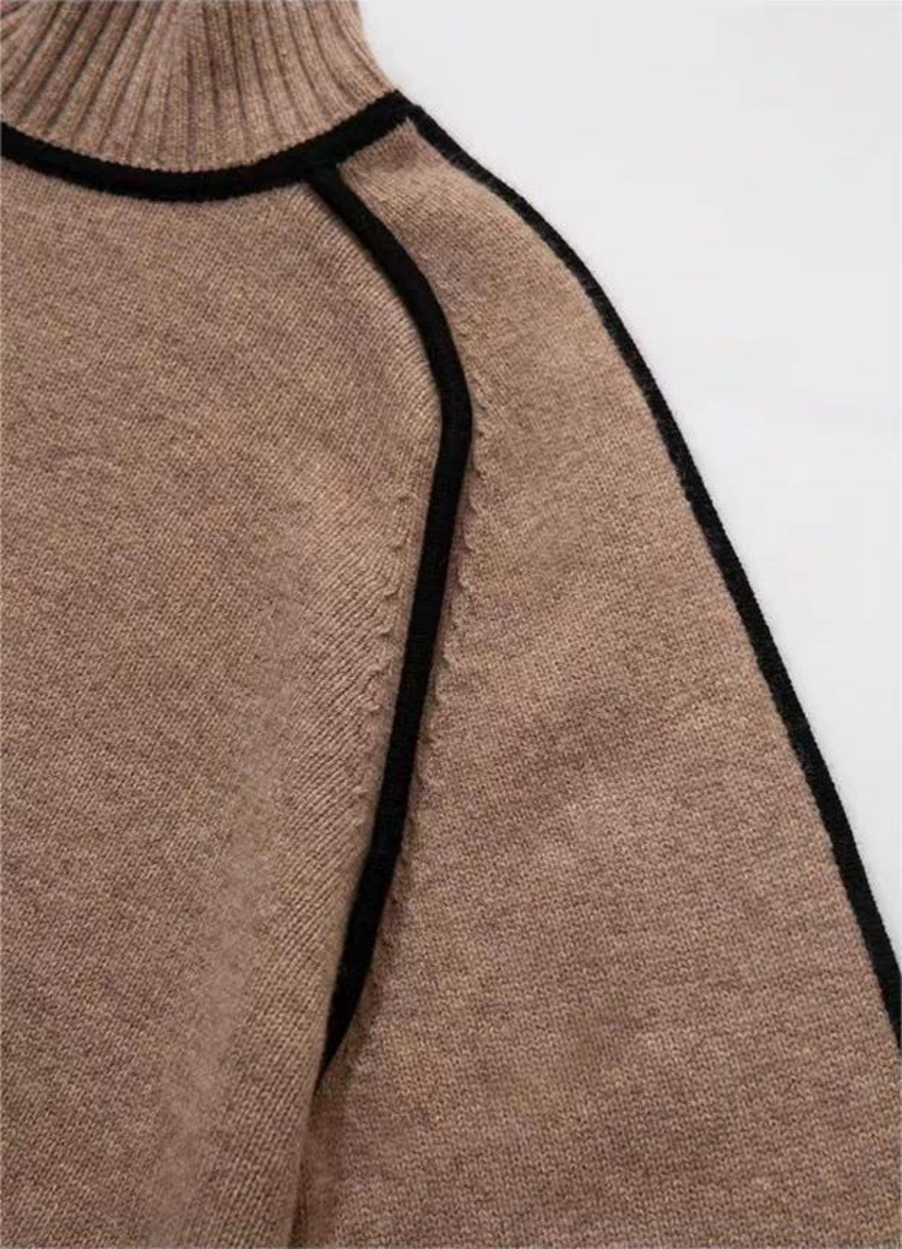 Close-up detail of half-high neck and raglan sleeve with black trim on new sweater
