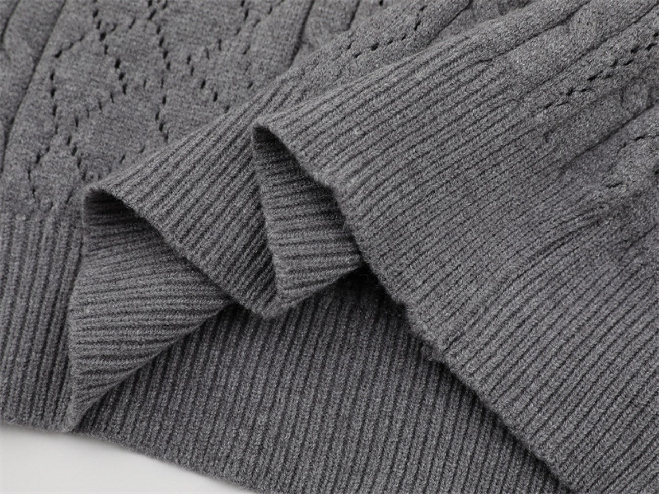 Hem finishing detail on gray polo collar sweater