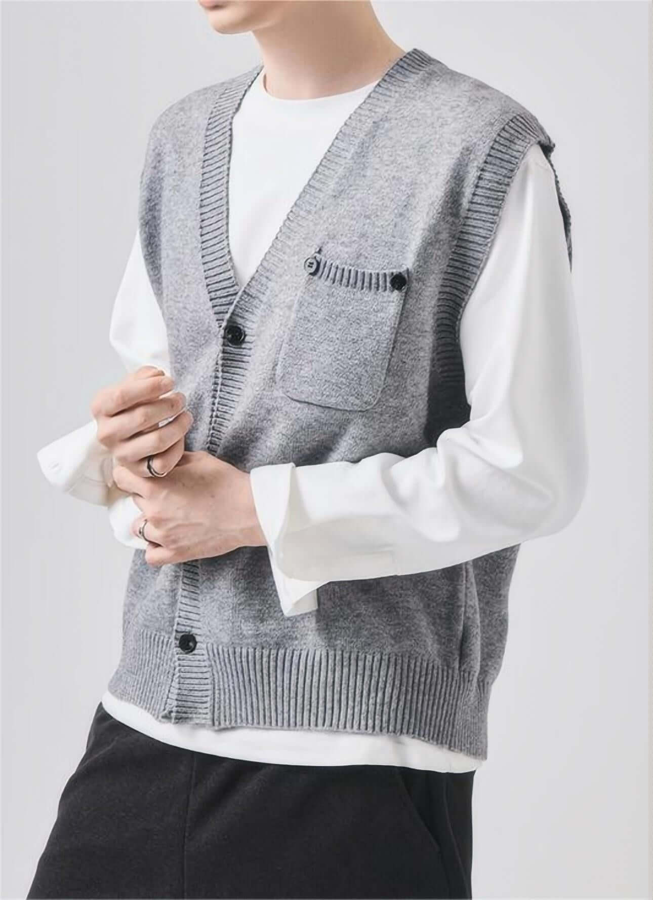 Man modeling gray sleeveless sweater with V-neck and chest pocket, front view.