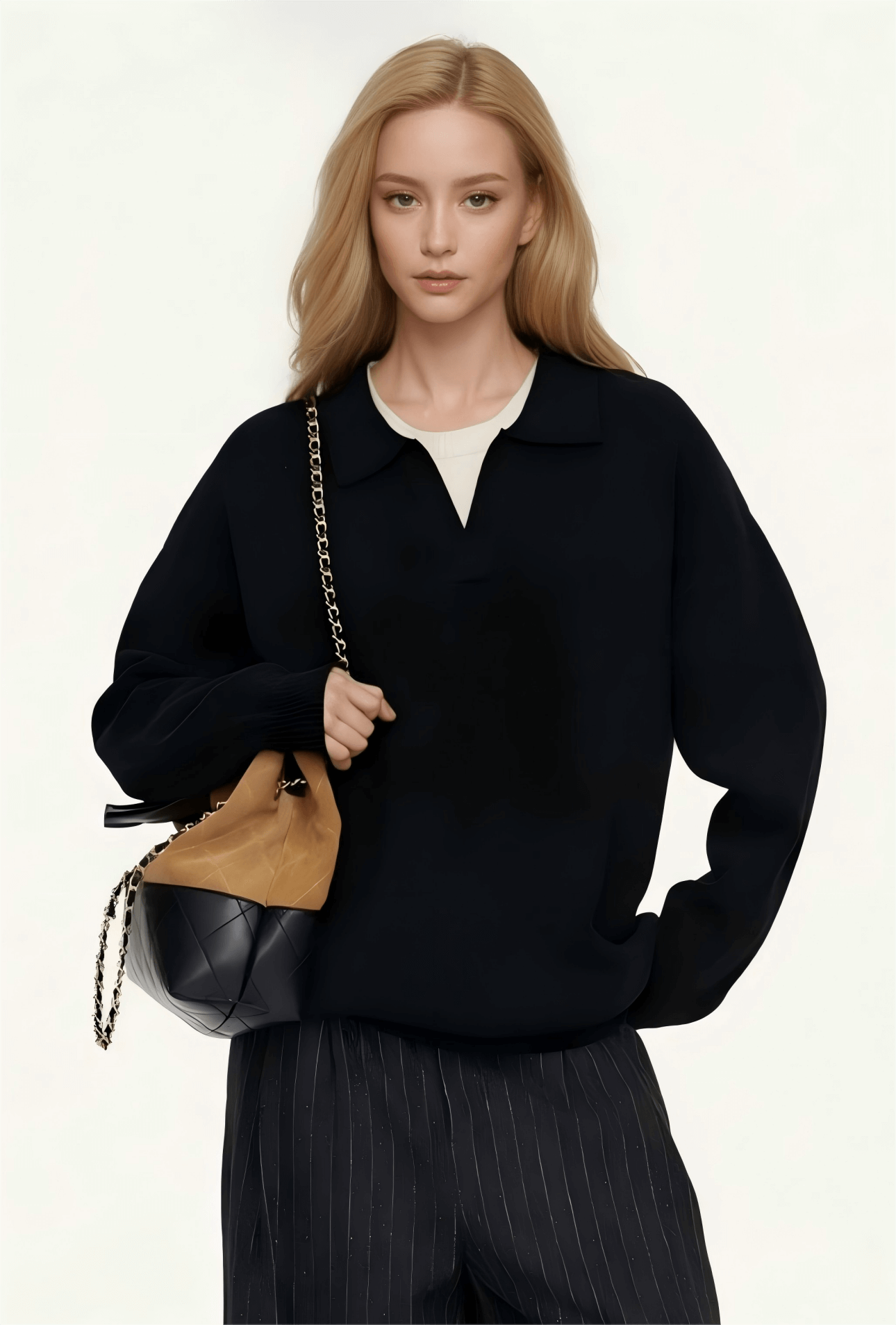Unisex Cashmere Sweater OEM in black mock neck style, model holding a stylish handbag.